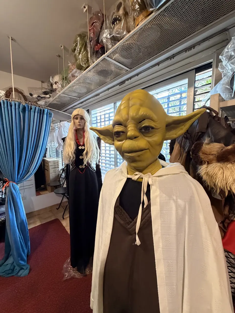 Interior del showroom de alquiler de disfraces en Almagro, con percheros y máscaras